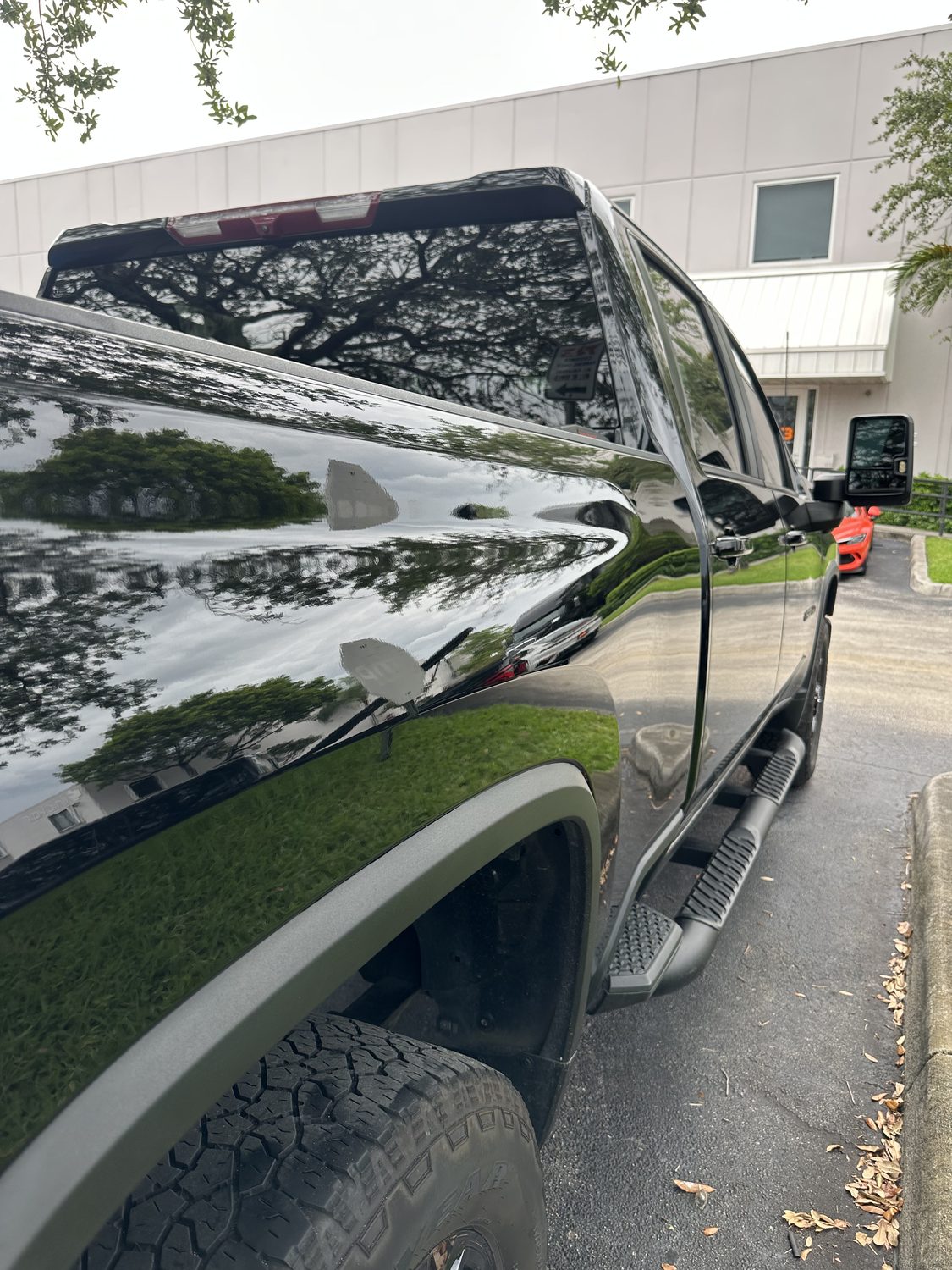 On-site mobile paintless dent repair on a black panel, Miami