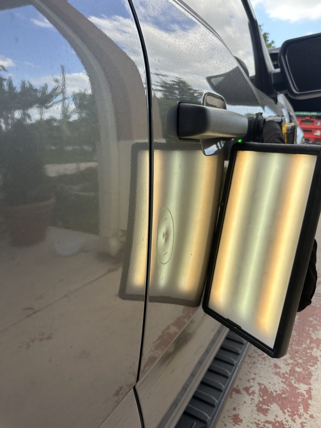 Marked dent on a dark panel before paintless dent repair, Miami