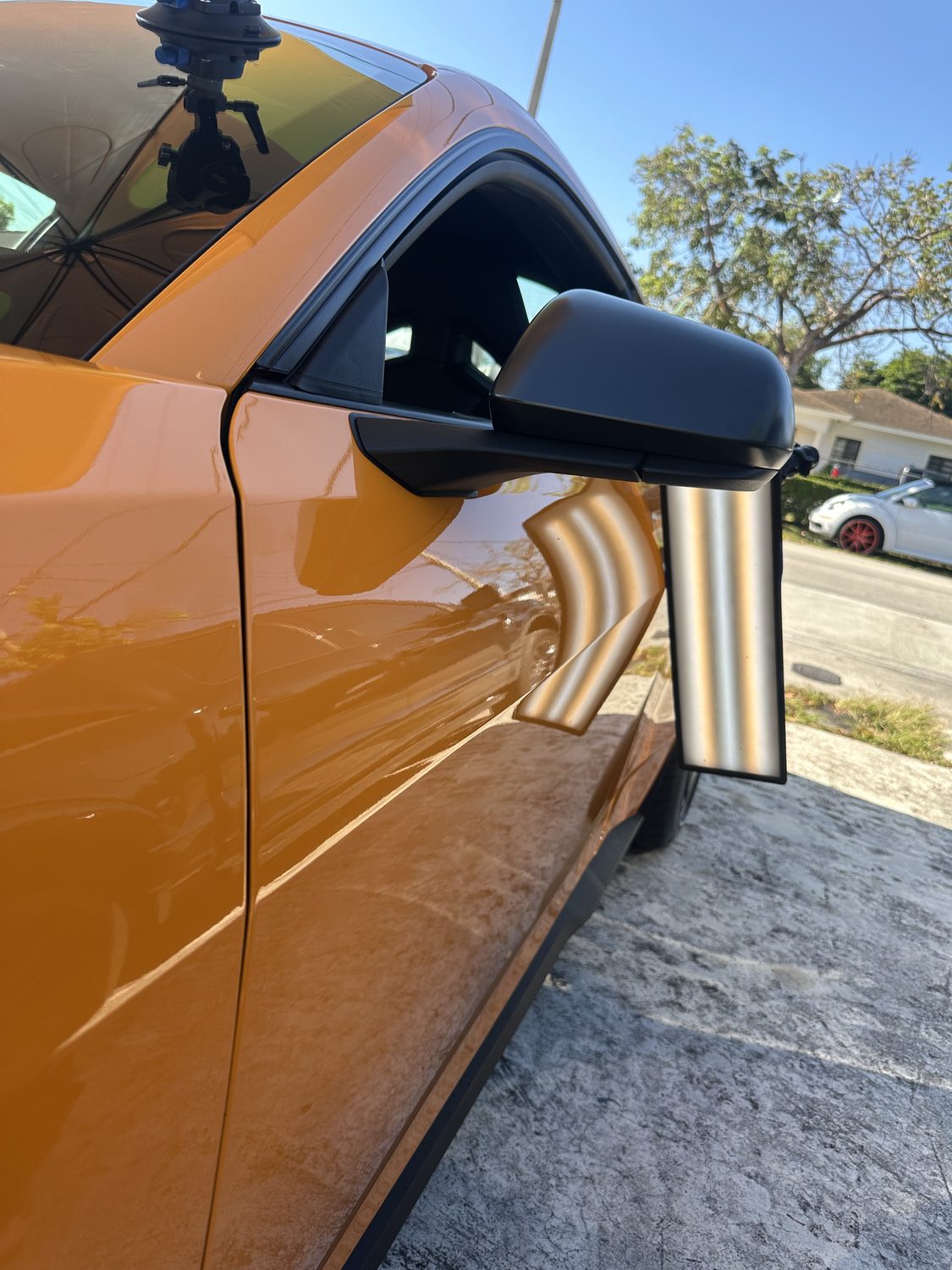Crease dent on a body line near the door mirror before paintless dent repair, Miami