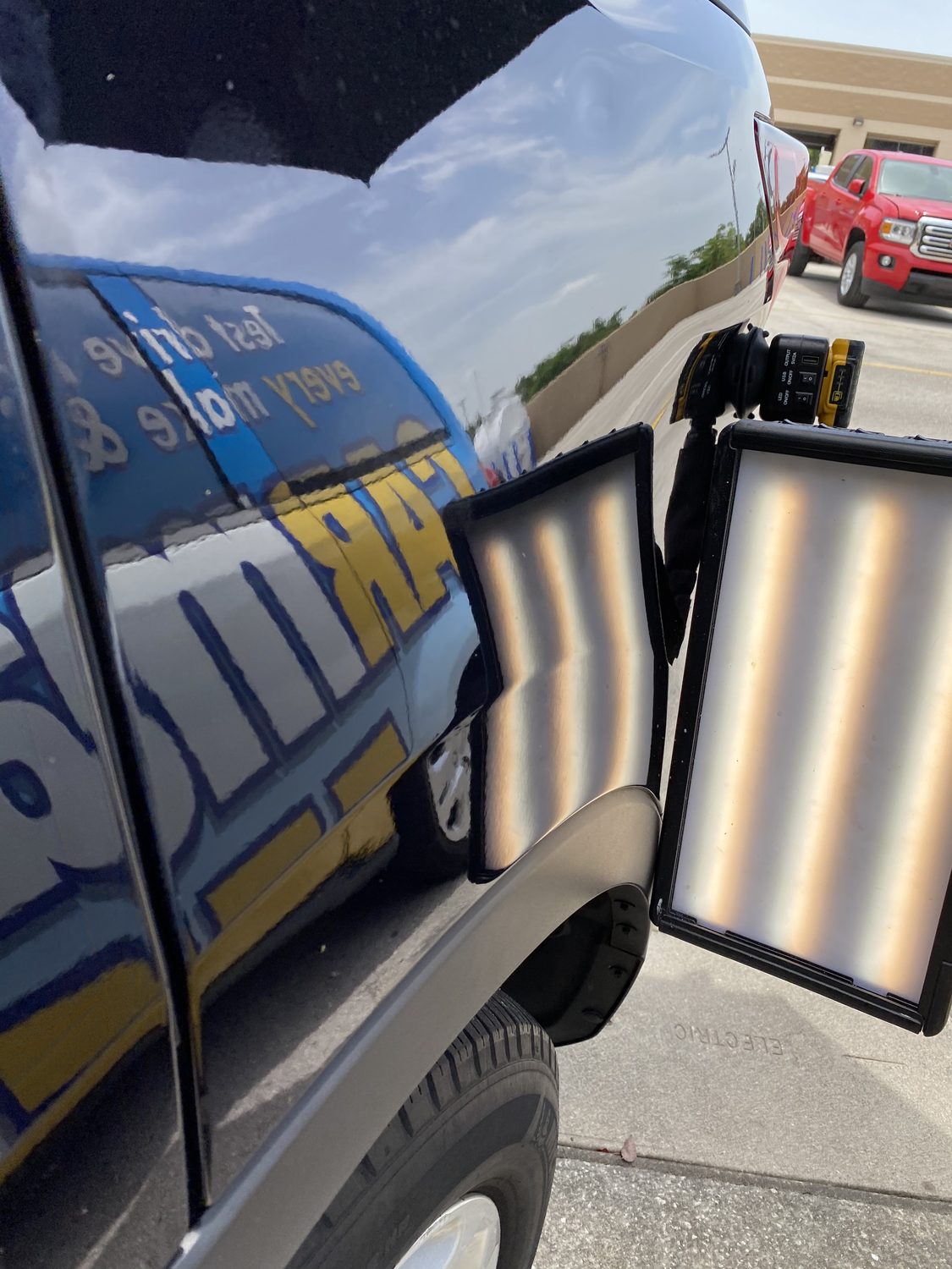 Dent on a black trunk panel before paintless dent repair, Miami