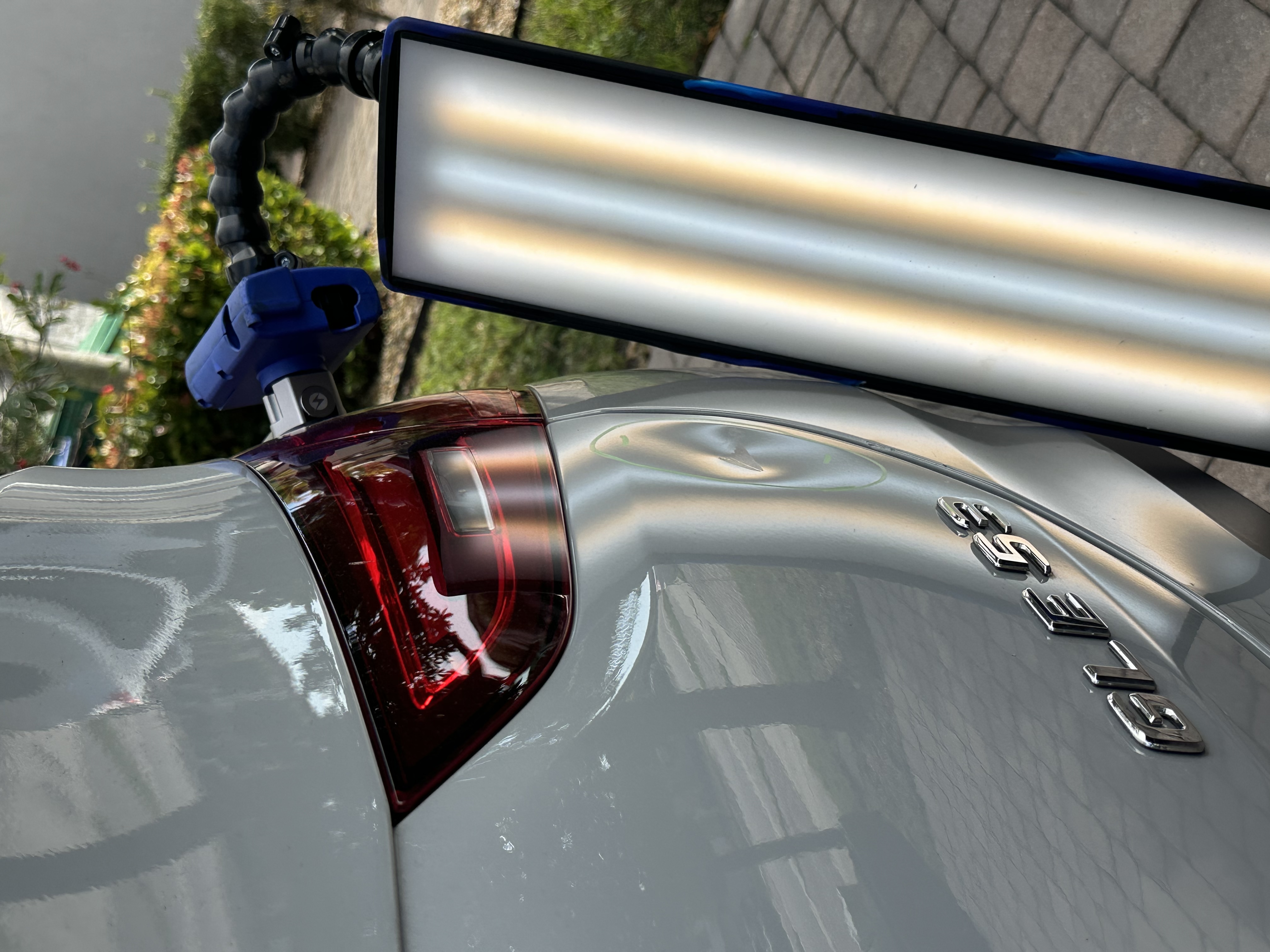 Dent near taillight on a silver Mercedes GLE shown under a PDR light board, Miami