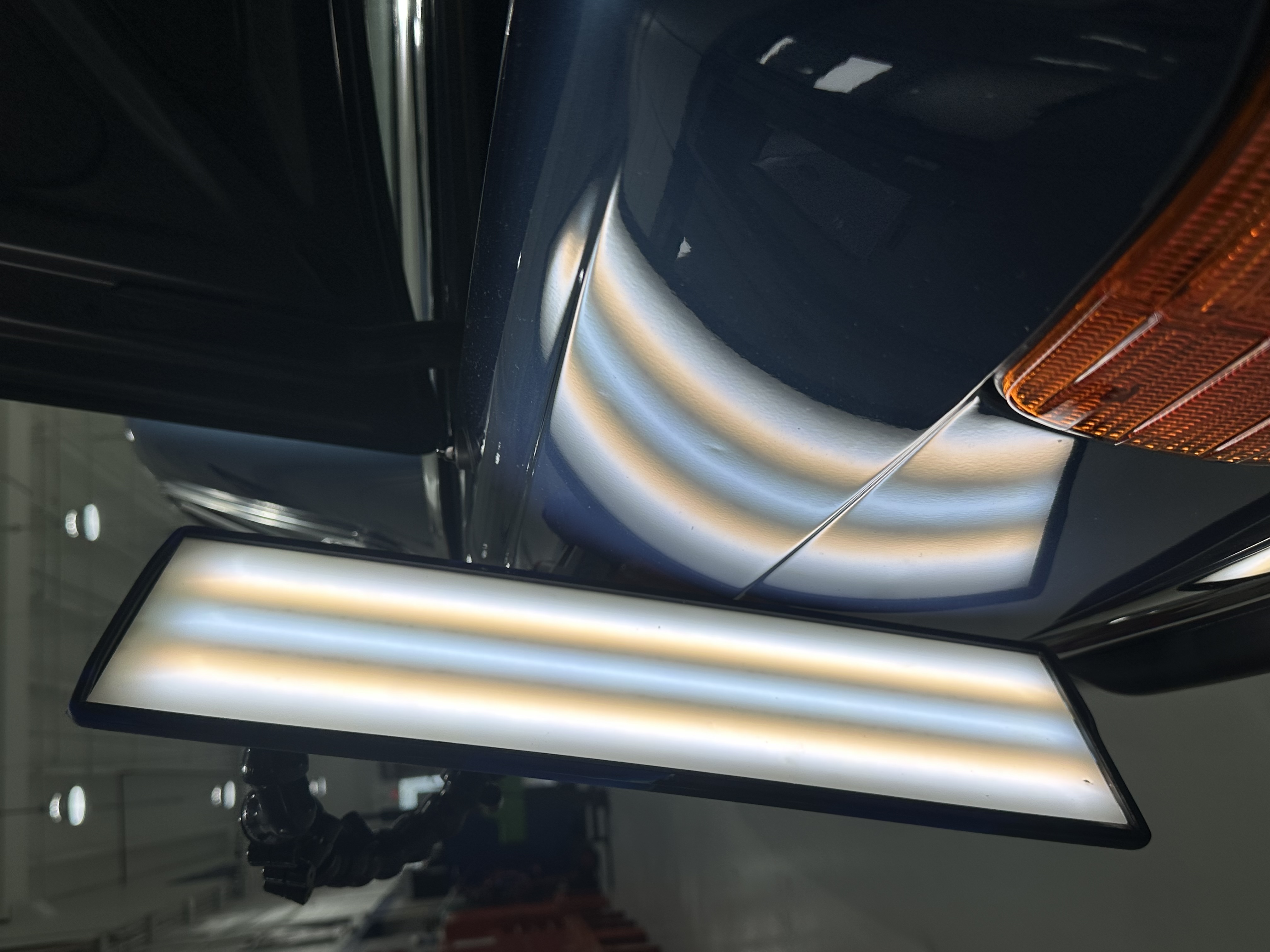 Dent on a navy panel shown under a PDR reflection board, Caliber PDR Miami